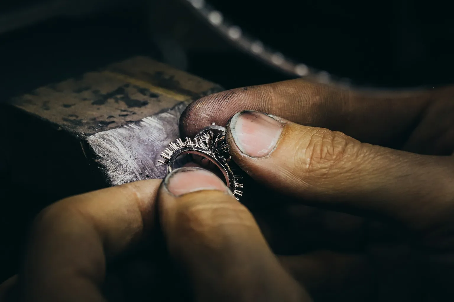 Hands polishing a silver ring at a jeweller’s bench